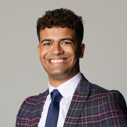 Photo of Haris head and shoulders wearing a tartan jacket white shirt and navy tie